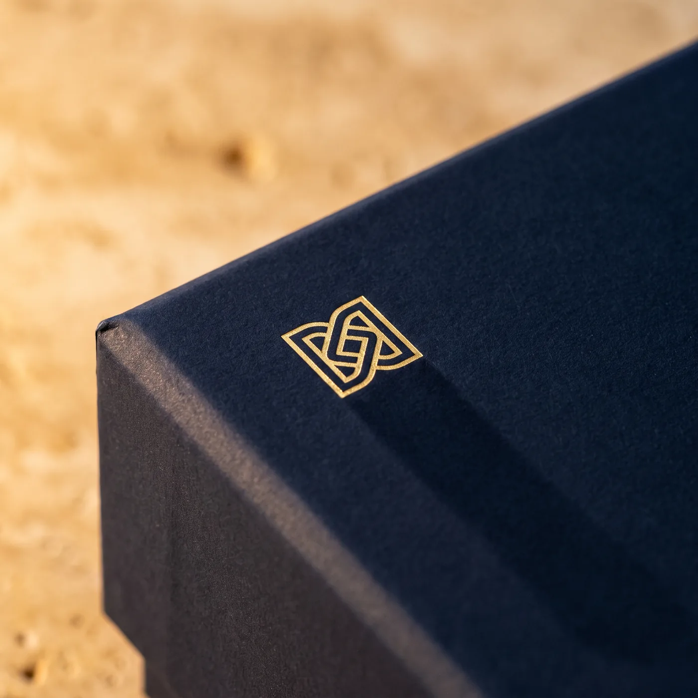 Gold foil emblem on navy soft-touch